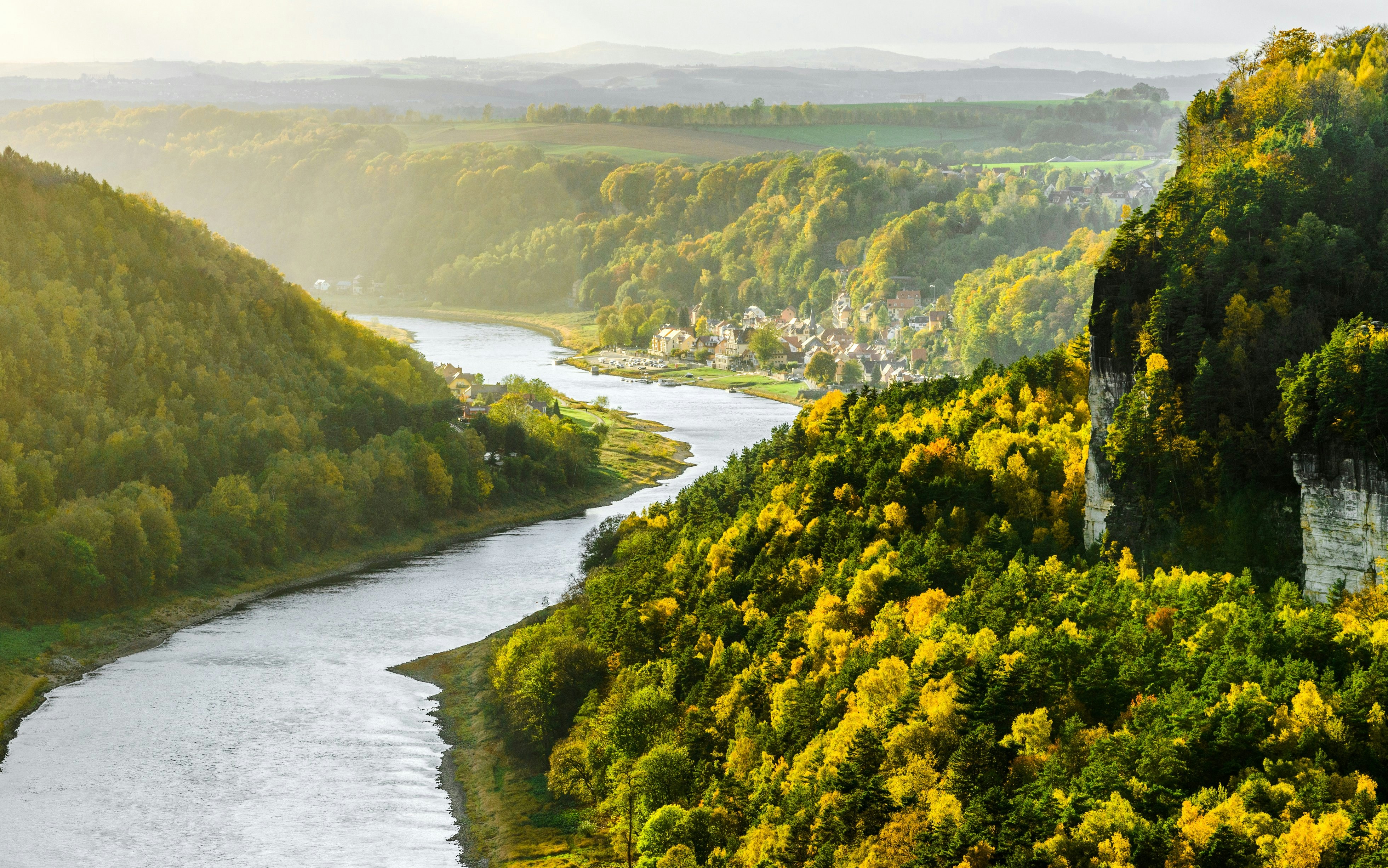 Elbe River winding through lush green hills from Bastei Bridge, Germany.
