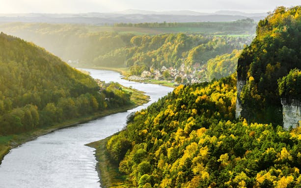 Elbe River winding through lush green hills from Bastei Bridge, Germany.