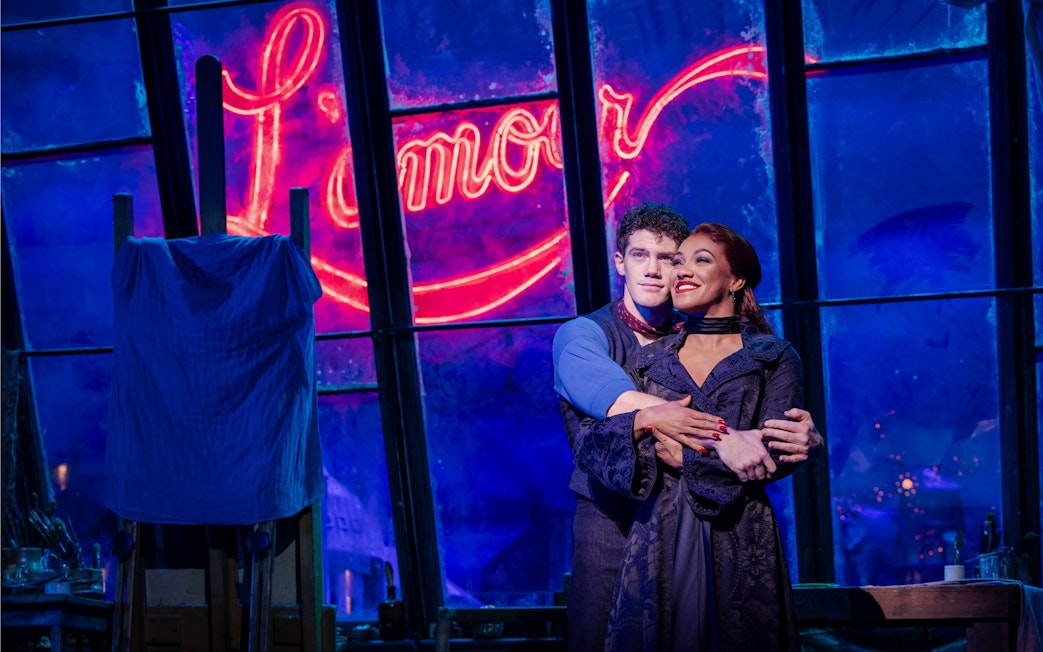 Stage performance of Come Alive Westend with actors embracing in front of neon sign.