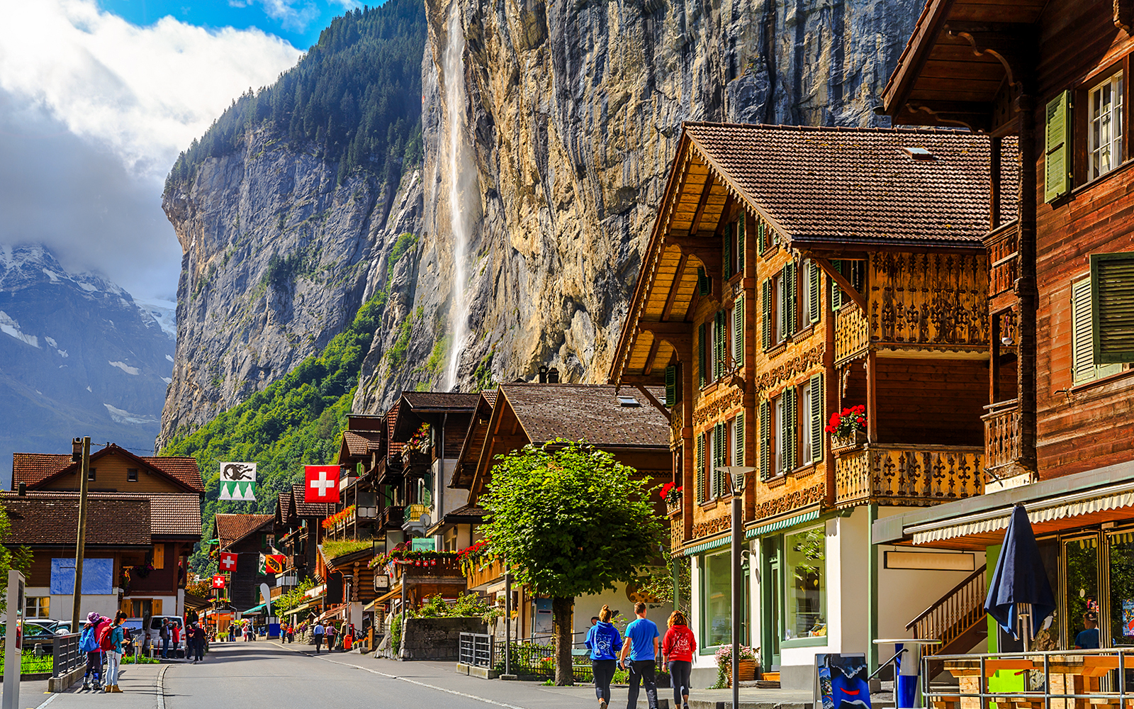 Lauterbrunnen street with traditional Swiss chalets and Staubbach waterfall, Bernese Oberland, Switzerland.