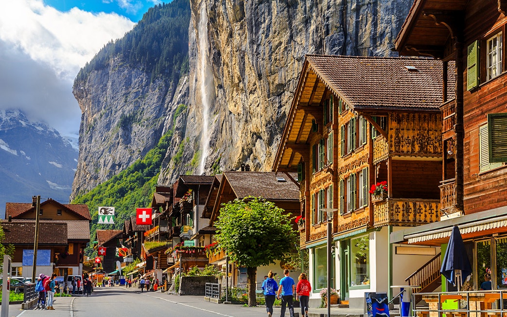 Lauterbrunnen street with traditional Swiss chalets and Staubbach waterfall, Bernese Oberland, Switzerland.