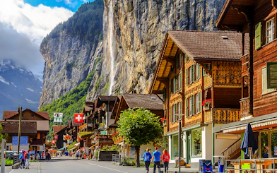 Lauterbrunnen street with traditional Swiss chalets and Staubbach waterfall, Bernese Oberland, Switzerland.