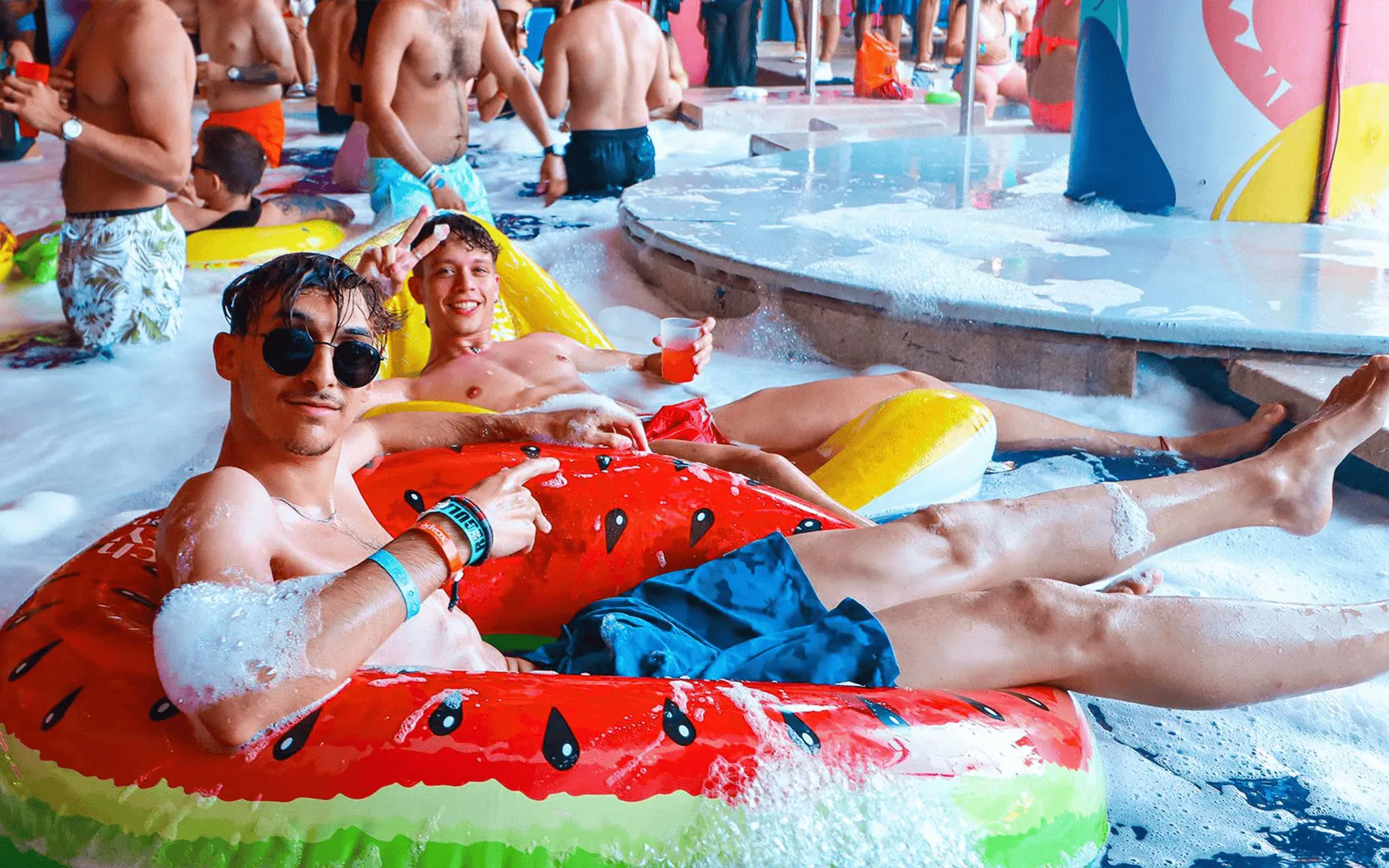 Guests enjoying foam party at Coco Bongo Beach Party in inflatable tubes.