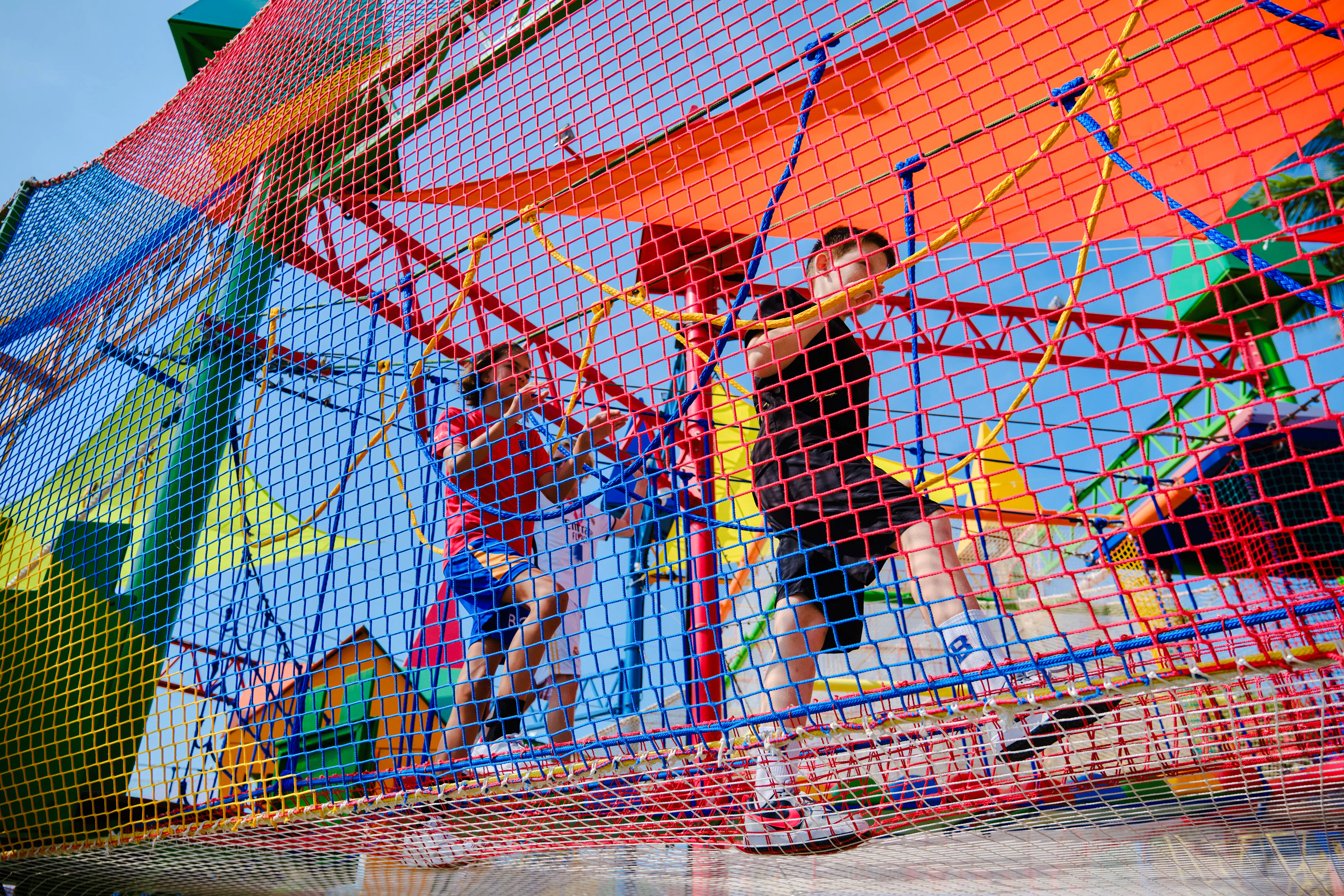 Children playing on a colorful climbing structure at Ko Fun Kids Park, Phuket.