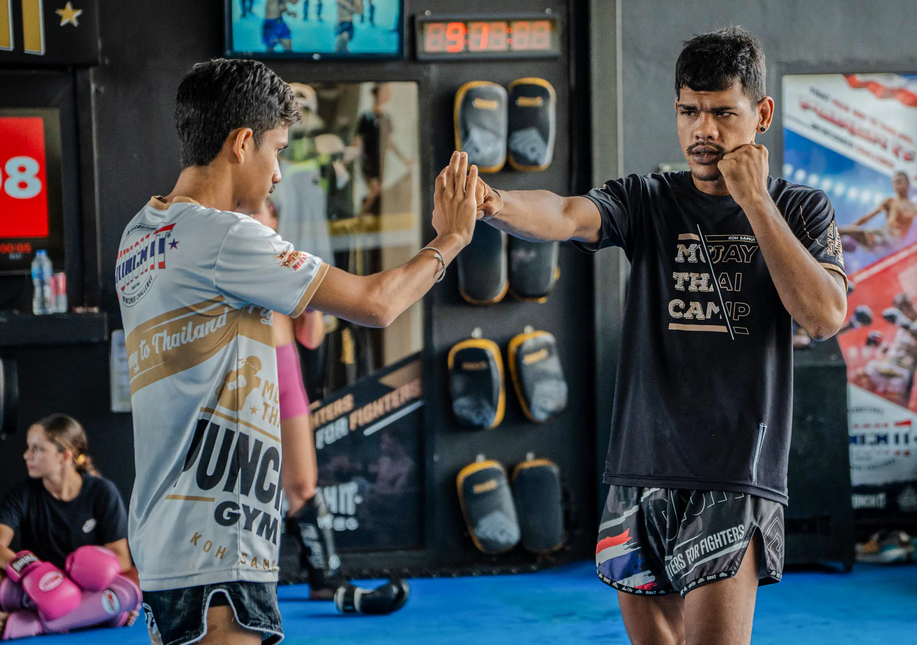 Muay Thai instructor and student practicing techniques at Koh Samui gym.