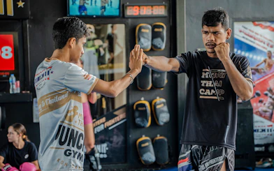 Muay Thai instructor and student practicing techniques at Koh Samui gym.