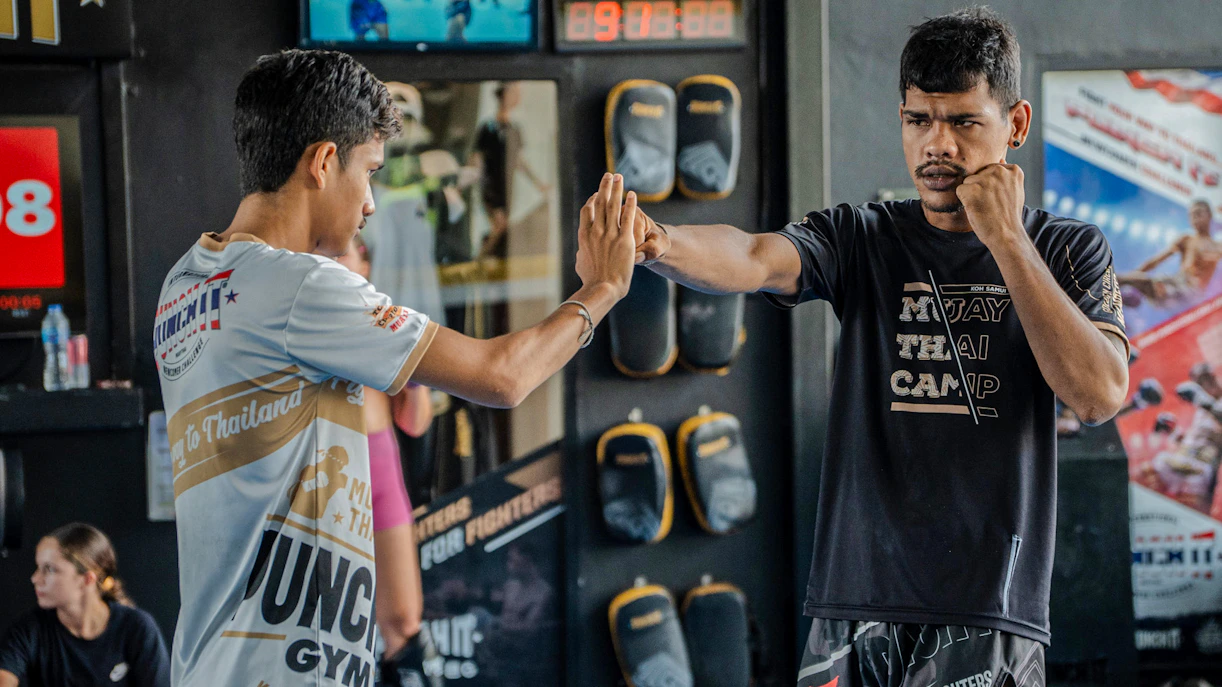 Muay Thai instructor and student practicing techniques at Koh Samui gym.