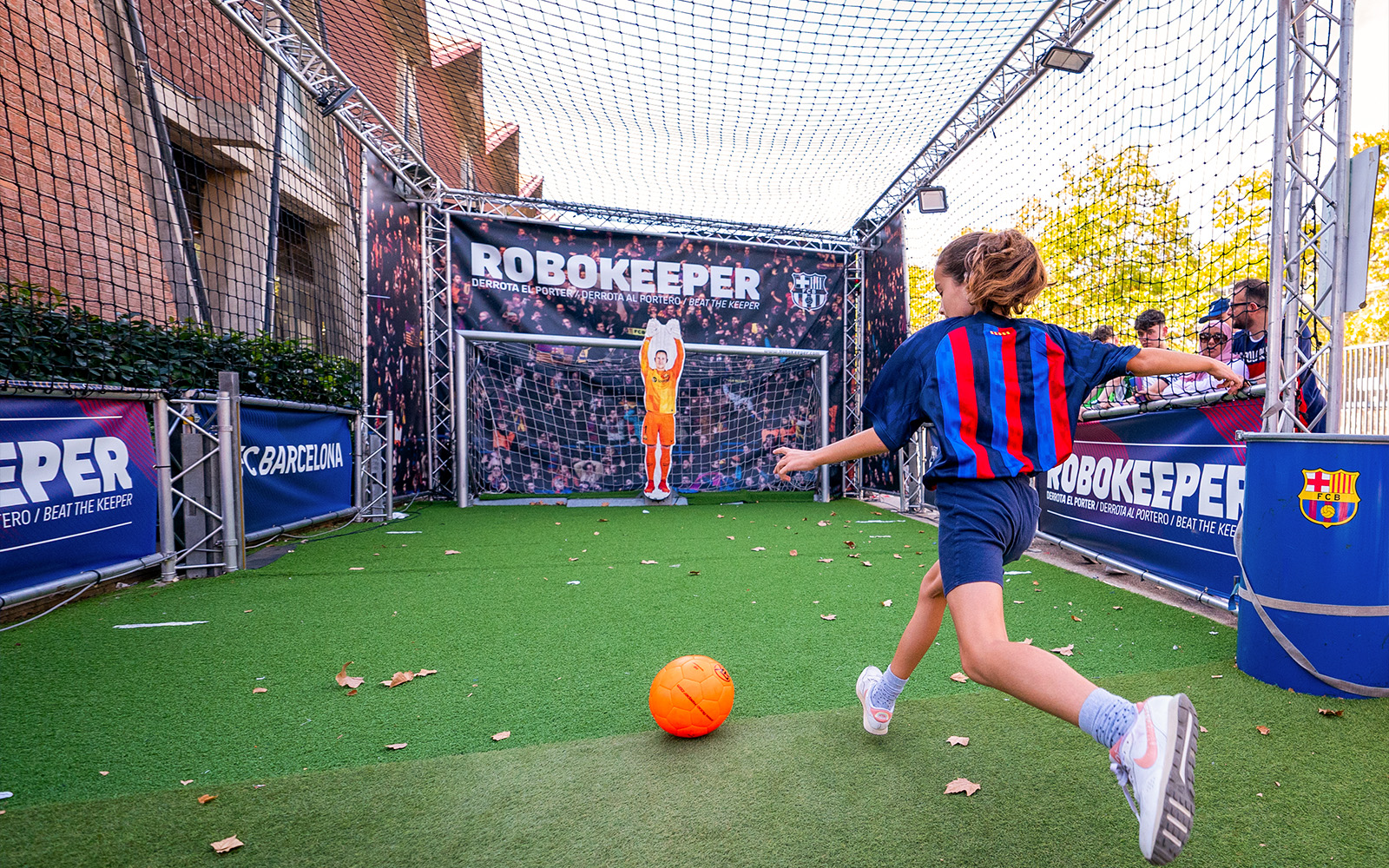 Child interacting with RoboKeeper exhibit at Camp Nou Barça Museum, Barcelona.