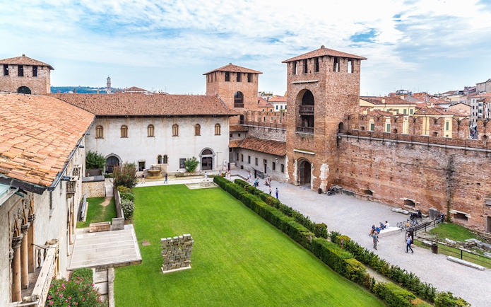 Castelvecchio Museum courtyard with historic walls and green lawn in Verona.