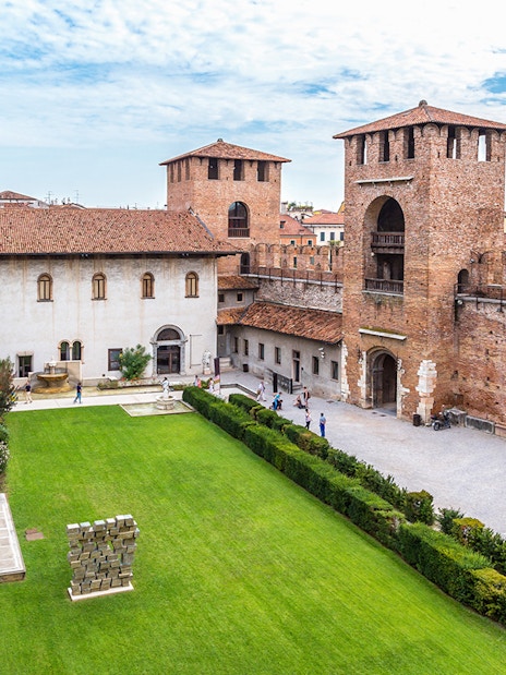 Castelvecchio Museum courtyard with historic walls and green lawn in Verona.