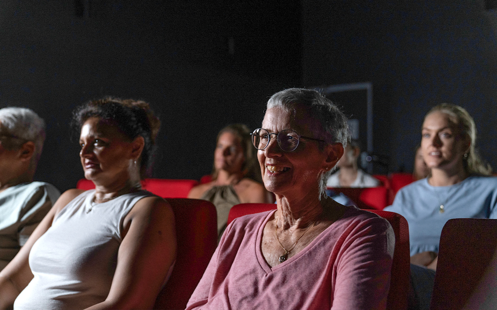 Visitors seated in a theater at the Darwin Royal Flying Doctor Service experience.