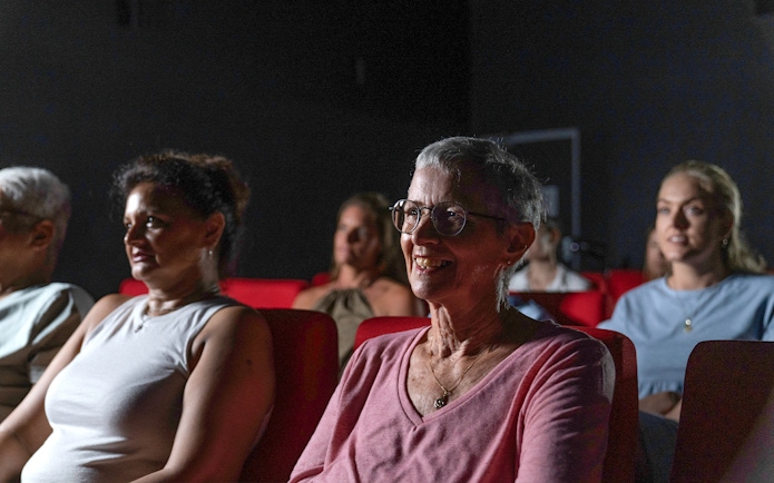 Visitors seated in a theater at the Darwin Royal Flying Doctor Service experience.