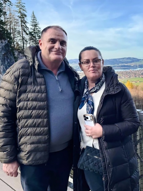 Visitors on a bridge with Neuschwanstein Castle in the background, Bavaria, Germany.