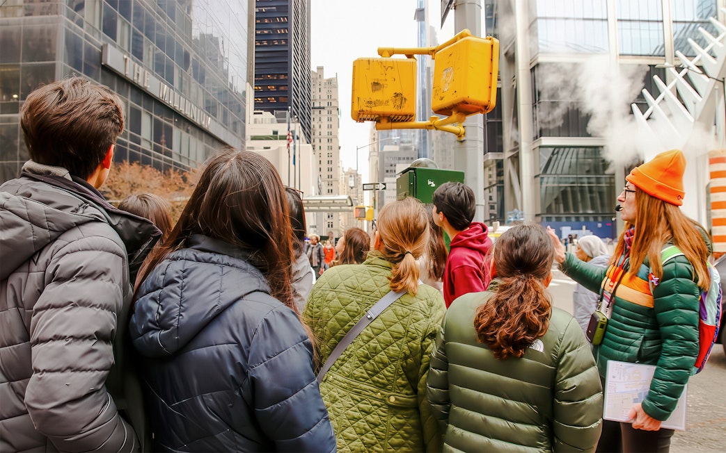 Group tour near One World Trade Center, New York City, listening to a guide.