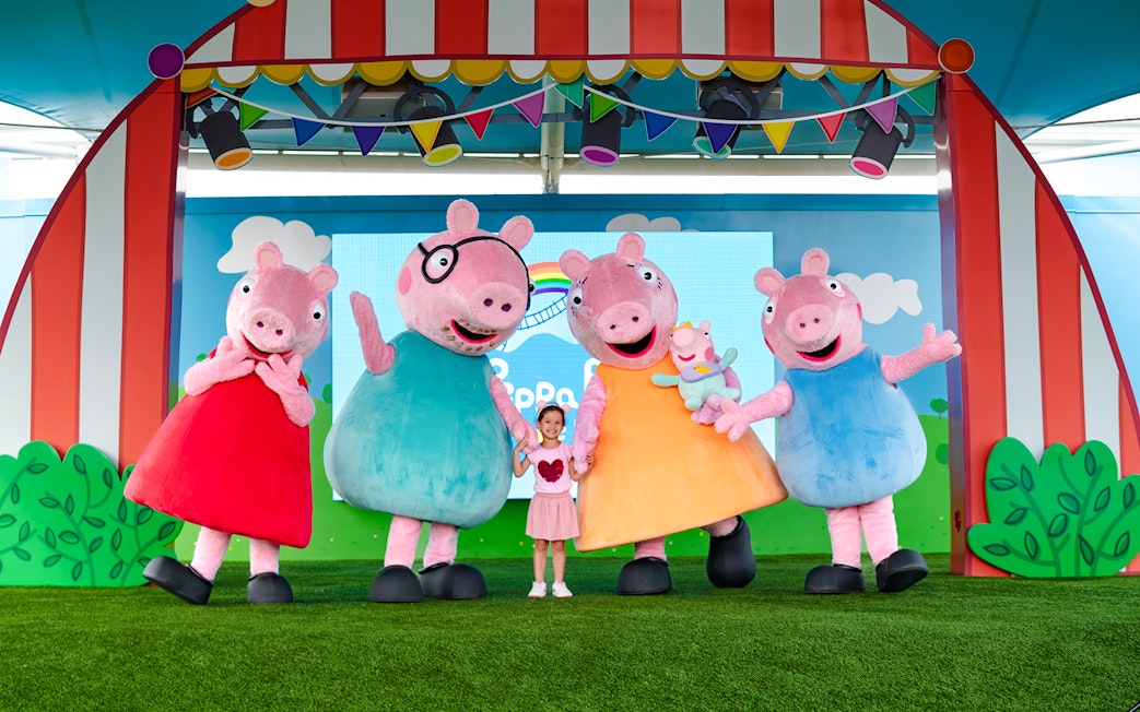 Peppa Pig characters with a child at Peppa Pig Theme Park, Florida.