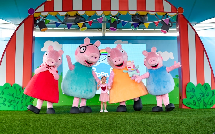 Peppa Pig characters with a child at Peppa Pig Theme Park, Florida.