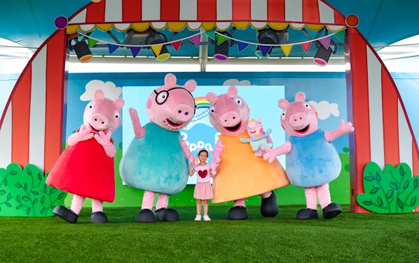 Peppa Pig characters with a child at Peppa Pig Theme Park, Florida.