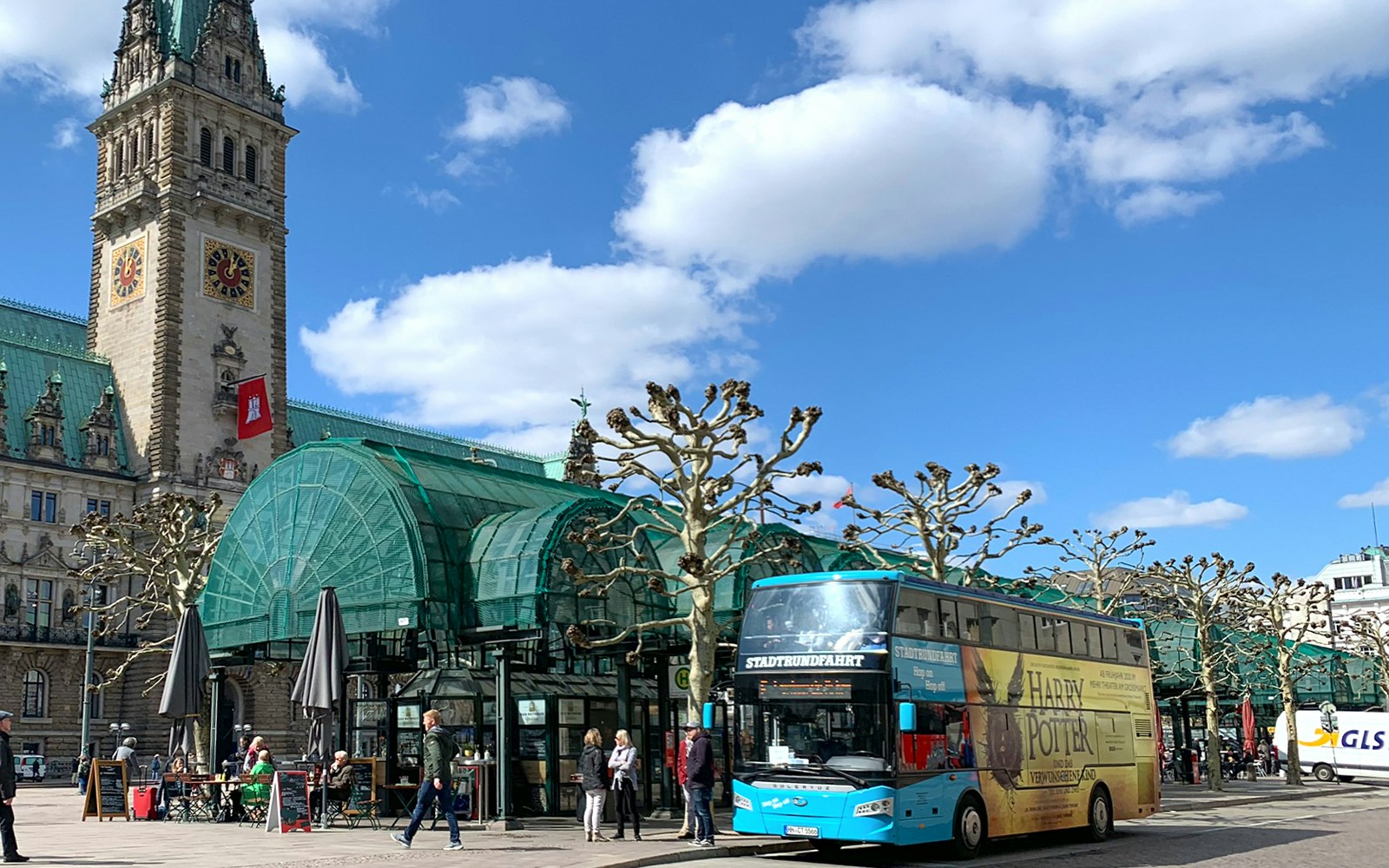 Hop on hop off tour bus in Hamburg passing by historic buildings and city landmarks.