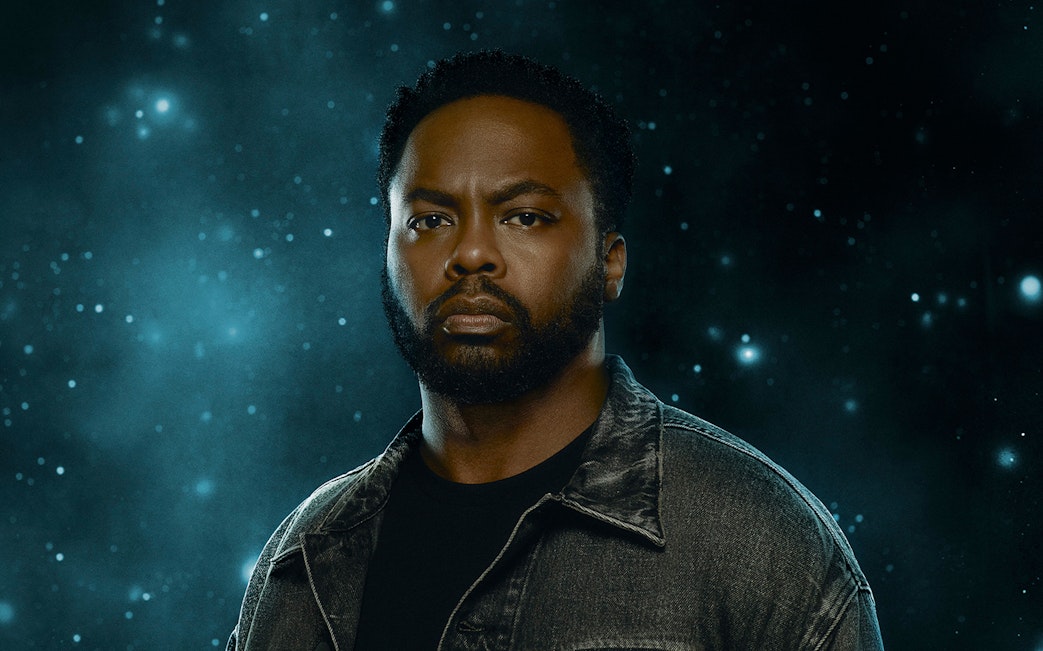 A person in a denim jacket against a starry background, related to "X: The Life and Times of Malcolm X.