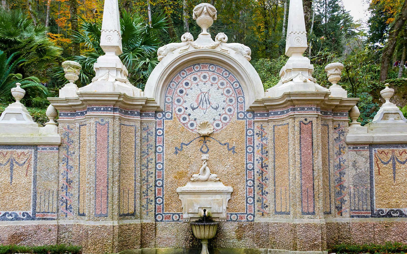Abundance Fountain at Quinta da Regaleira, Sintra, Portugal with intricate stone carvings and lush greenery.