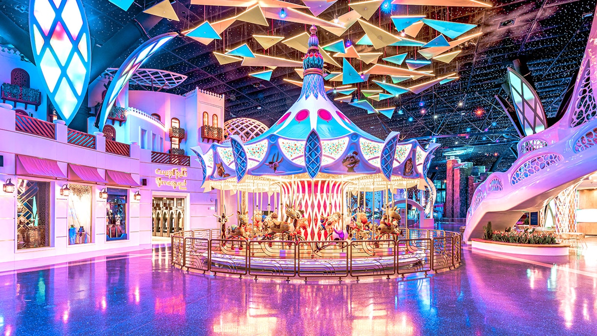 Carousel ride at Doha Quest Theme Park with vibrant lights and colorful decor.