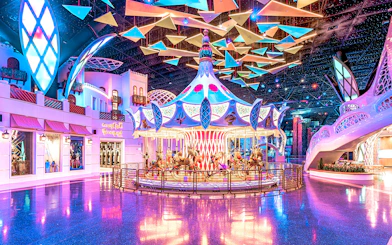 Carousel ride at Doha Quest Theme Park with vibrant lights and colorful decor.