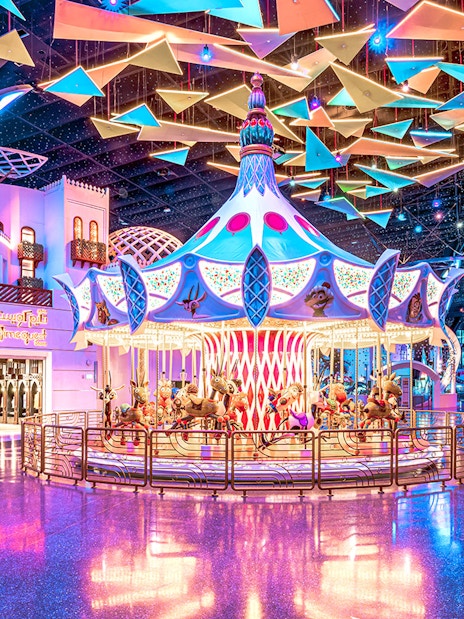 Carousel ride at Doha Quest Theme Park with vibrant lights and colorful decor.