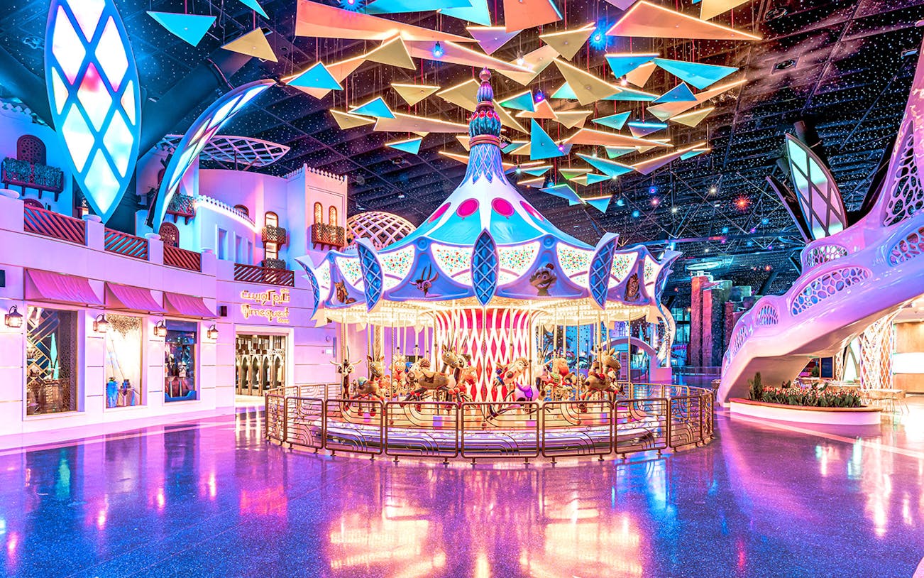 Doha Quest Theme Park indoor roller coaster with vibrant lights and futuristic design.