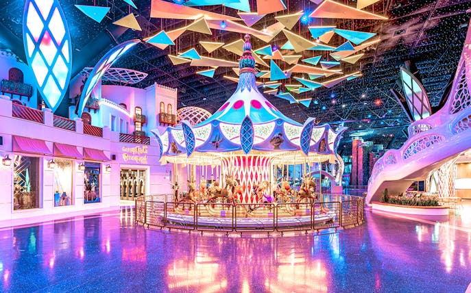 Carousel ride at Doha Quest Theme Park with vibrant lights and colorful decor.