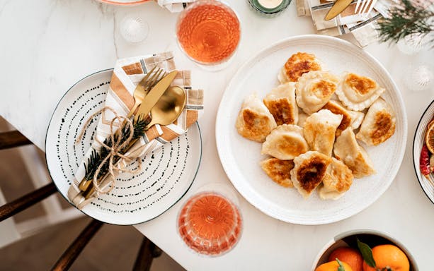 Plate of pierogi on a table set for a traditional Polish food tour.