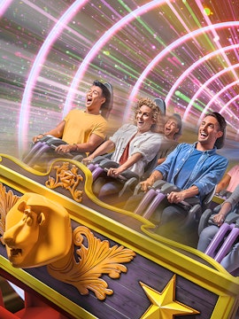 People enjoying a thrilling roller coaster ride with colorful light tunnel.
