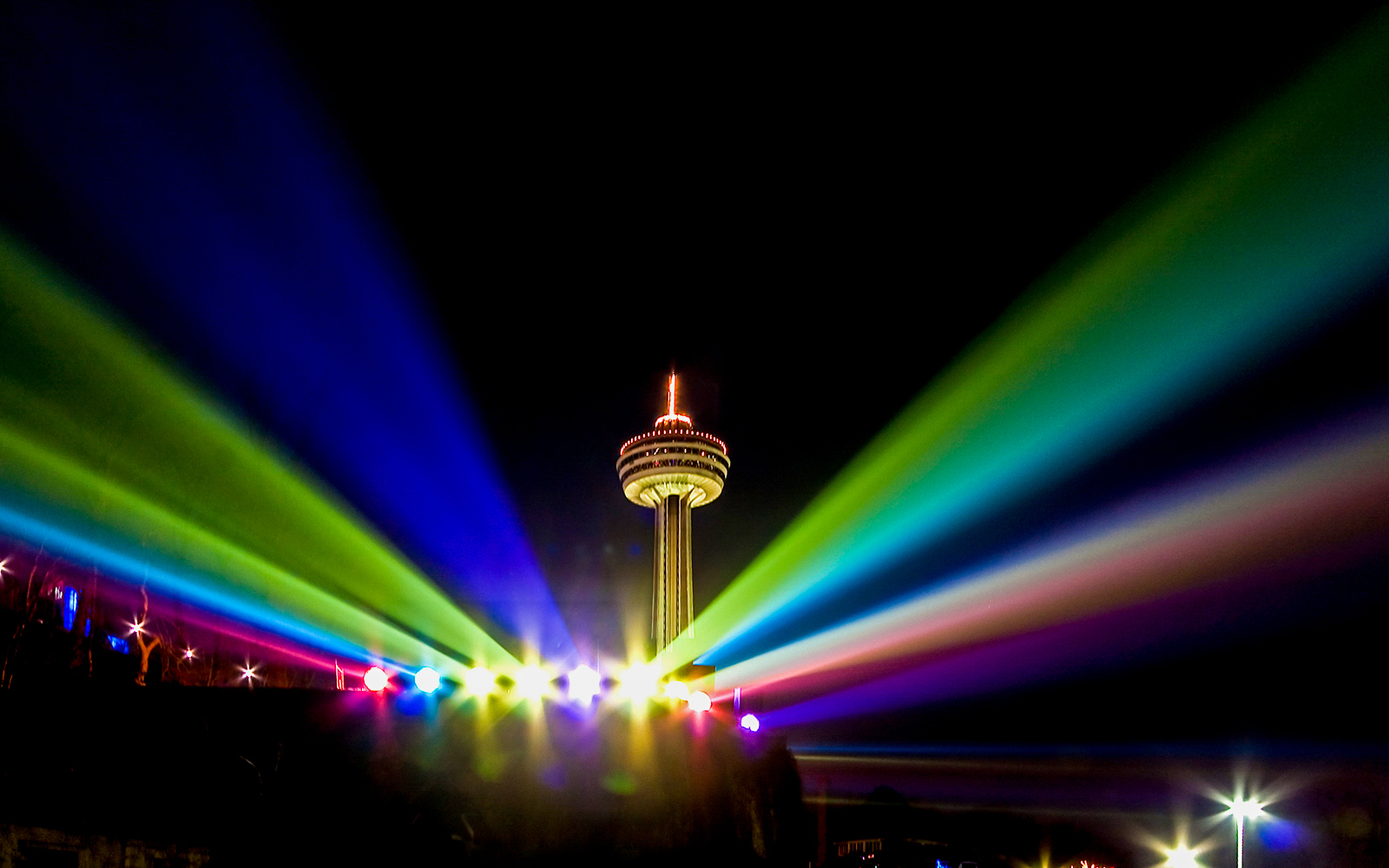 Skylon Tower in Niagara Falls illuminated with colorful lights at night.