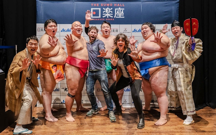 Tourists with sumo wrestlers at Sumo Hall Hirakuzu, Osaka.