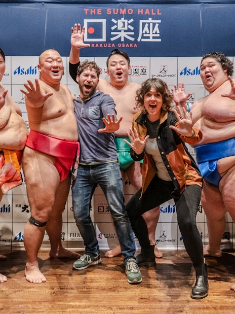 Tourists with sumo wrestlers at Sumo Hall Hirakuzu, Osaka.
