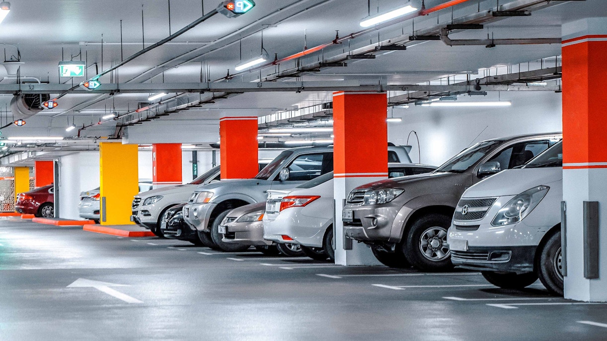 Underground parking area with multiple parked cars in a well-lit facility.