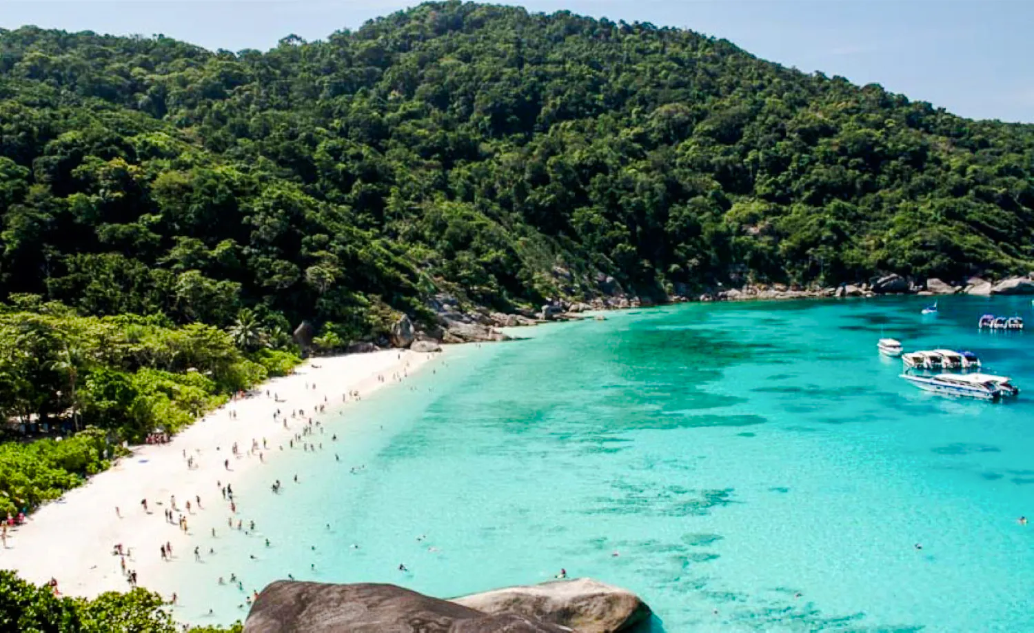 Surin Islands beach with tourists and speedboats in turquoise water, Krabi day tour.