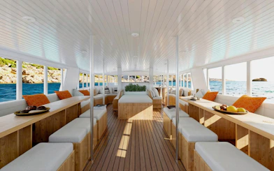 Interior of Ibiza cruise boat with seating and ocean view during Formentera Cruise Tour.