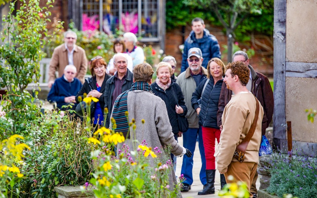 Group enjoying a guided tour in a garden setting.