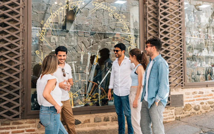 Friends with guide exploring historic Toledo streets.