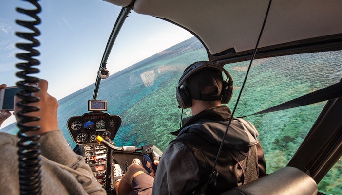 Helicopter cockpit view over the Great Barrier Reef, Australia.