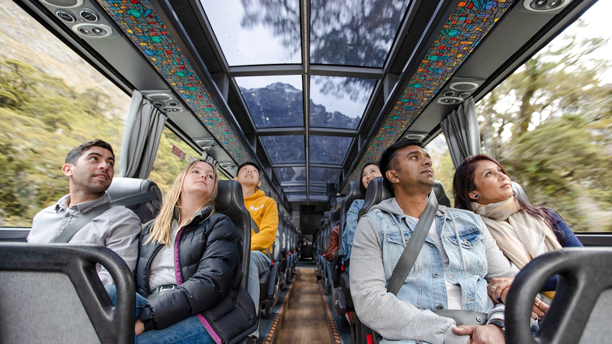 Passengers on a scenic bus tour from Auckland to Hobbiton, Waitomo Caves, and Te Puia.