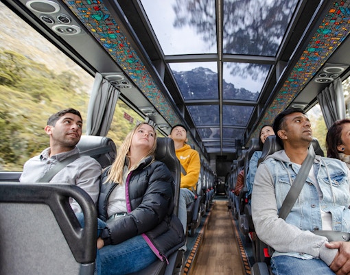 Passengers on a scenic bus tour from Auckland to Hobbiton, Waitomo Caves, and Te Puia.