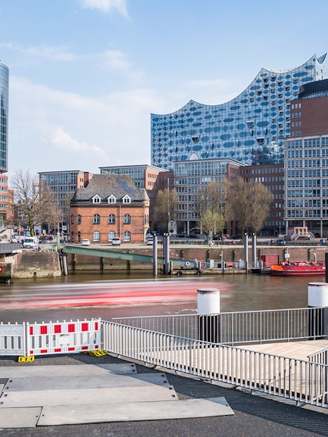 Elbphilharmonie in Hamburg with surrounding modern buildings and a bridge over the river.
