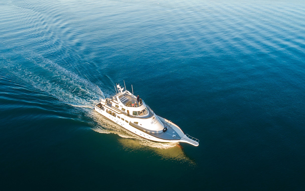 Luxury yacht cruising on open blue water.