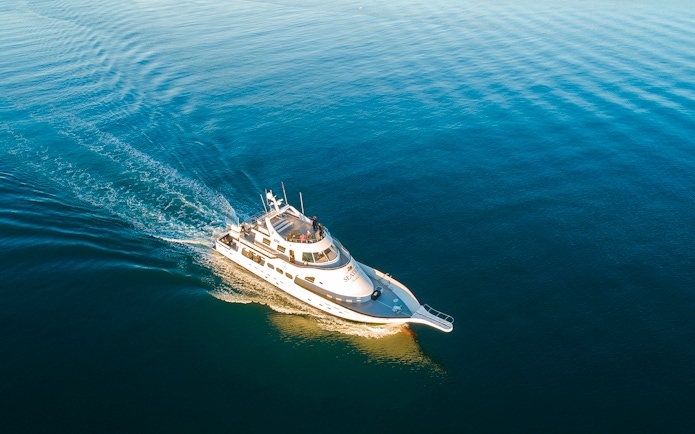 Luxury yacht cruising on open blue water.