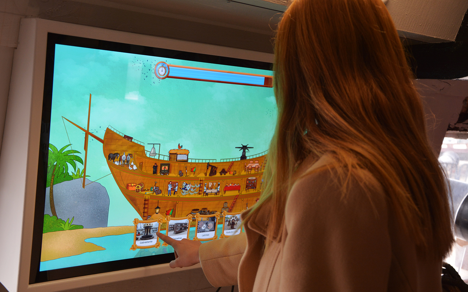 Interactive display of Frigate D. Fernando II e Glória with a person engaging with the touchscreen.