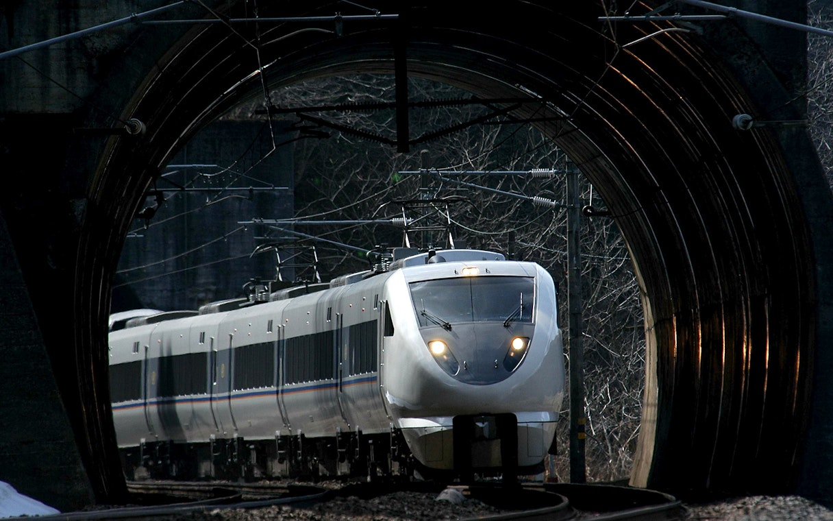 High-speed train exiting tunnel in Hokuriku region, Japan.