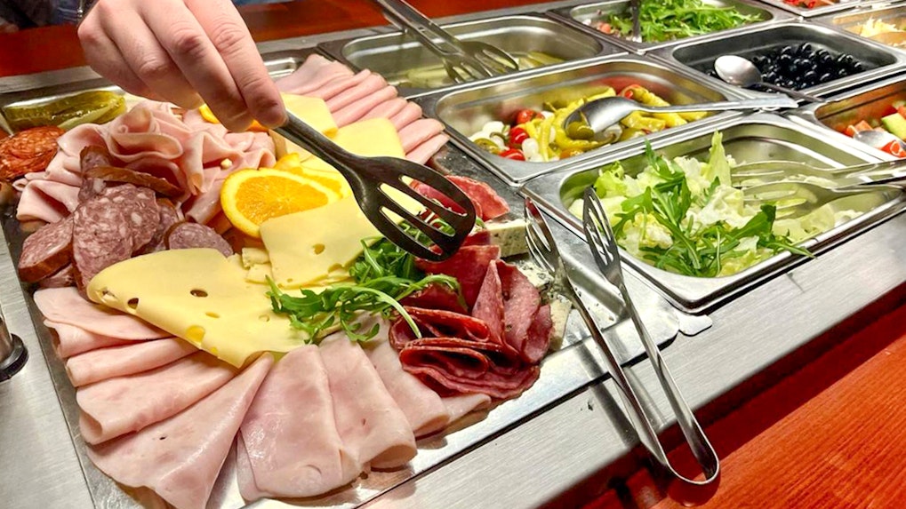 Assorted meats and cheeses on a buffet during Prague sightseeing boat cruise.
