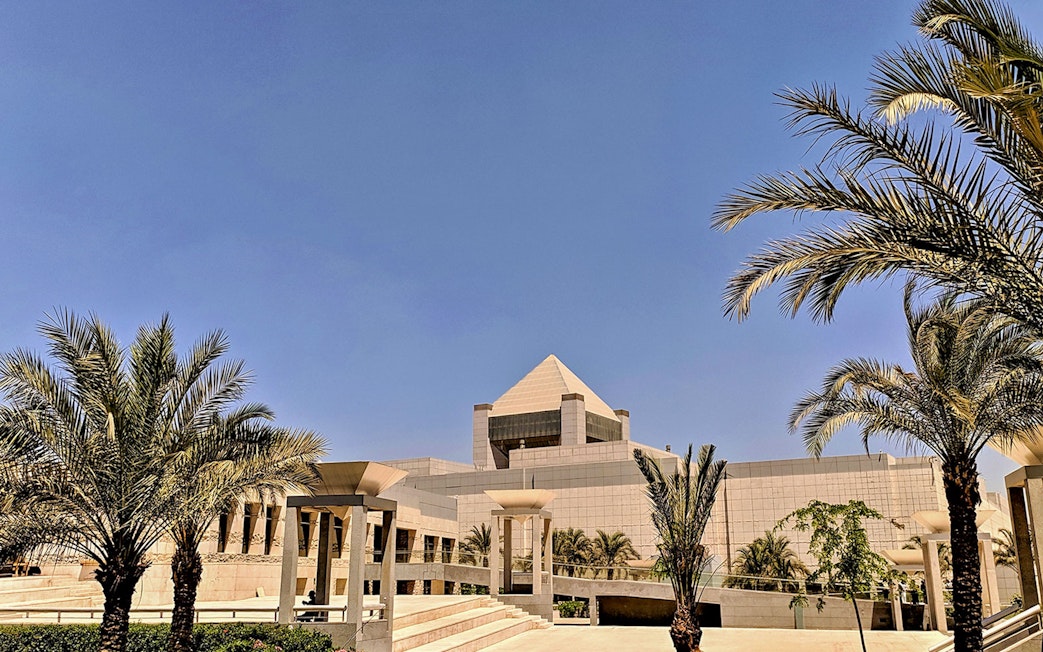 National Museum of Egyptian Civilization in Cairo with palm trees and modern architecture.