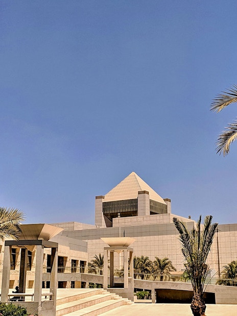 National Museum of Egyptian Civilization in Cairo with palm trees and modern architecture.